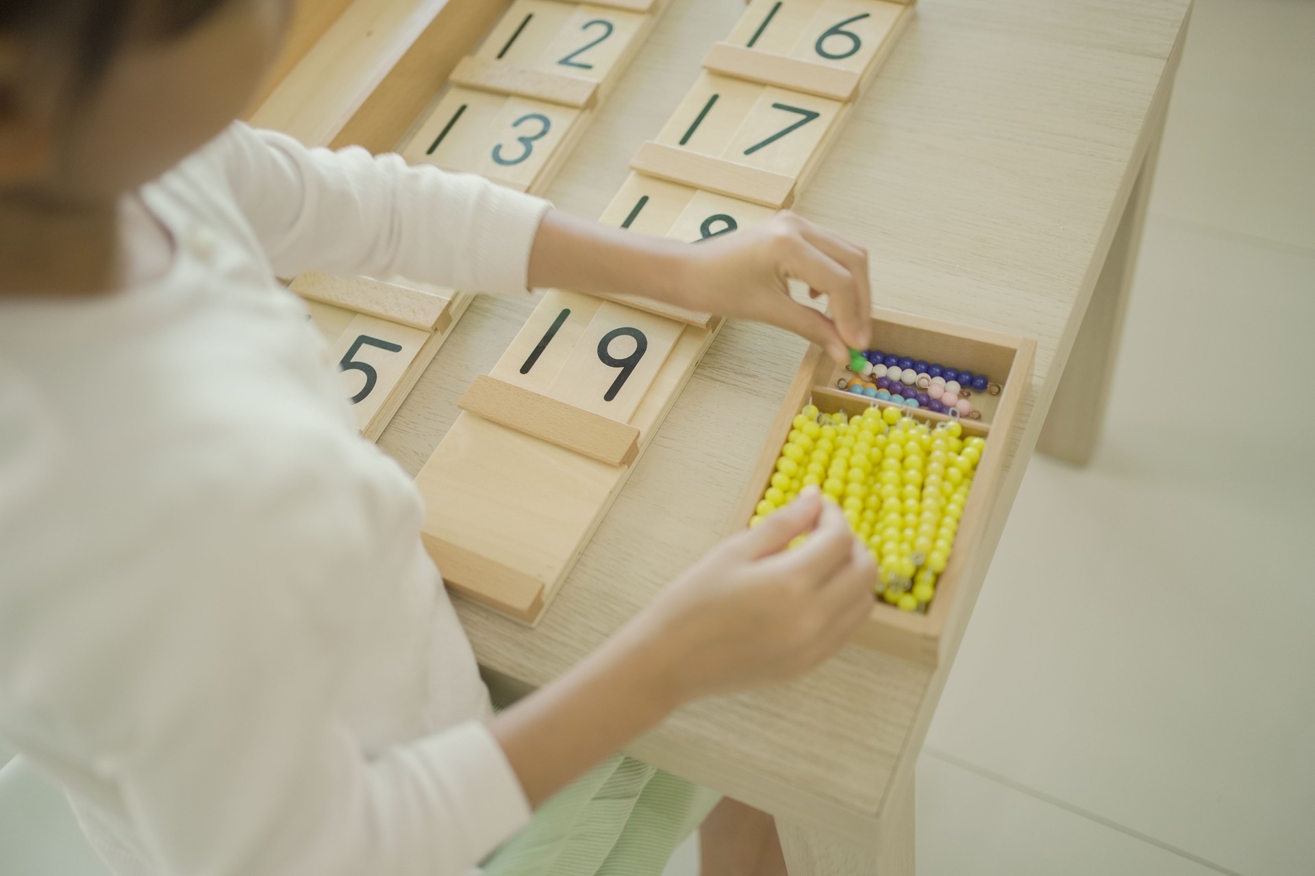 Elementary girl using color bead chain to learn mathematics